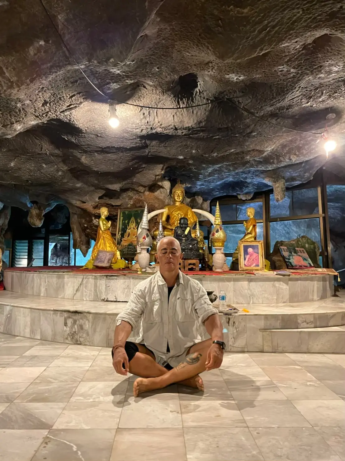 Karol Krauser meditating in Thai Buddhist cave temple representing mind-body integration and inner focus