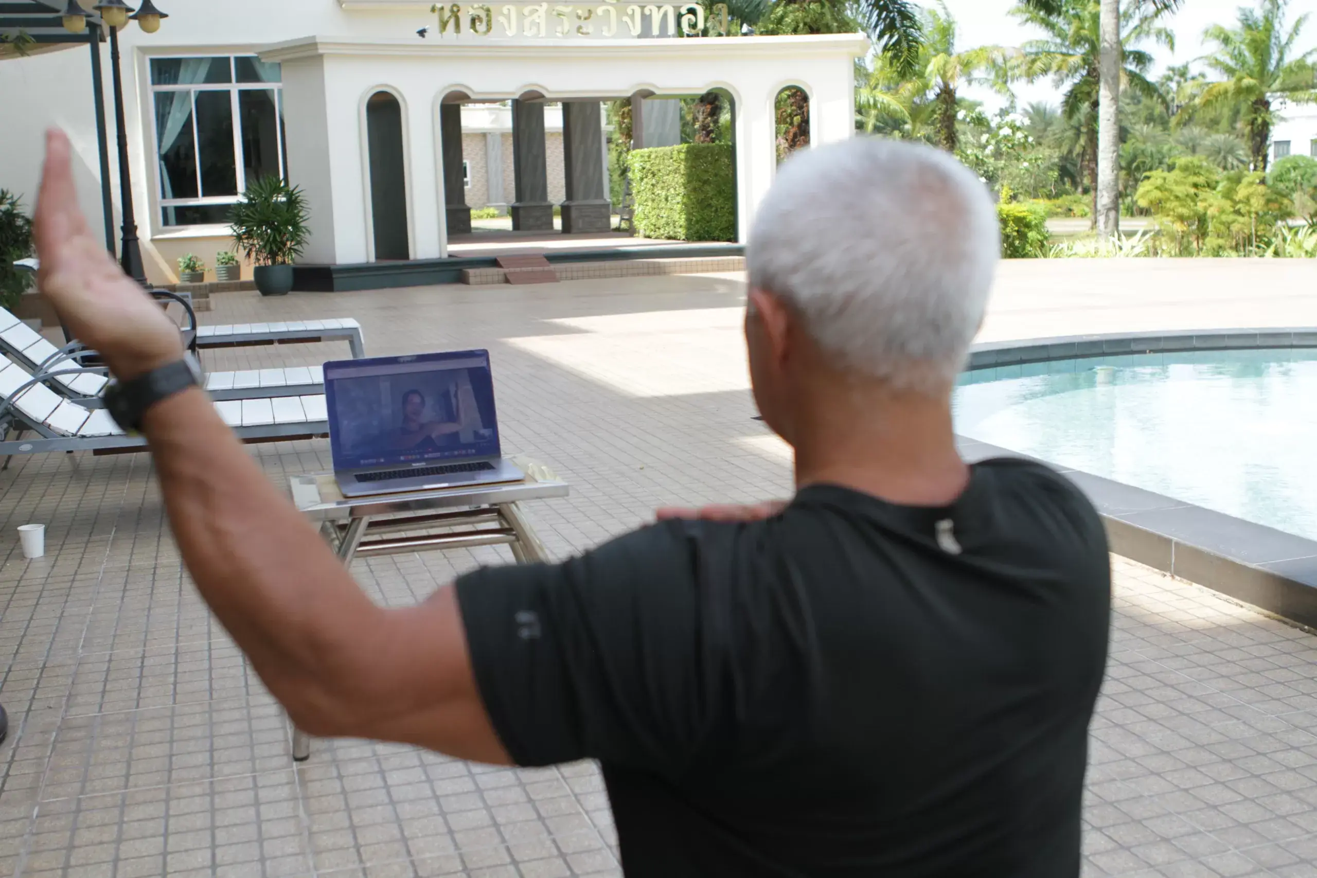 Karol Krauser conducting online NLP coaching video session from poolside in Phuket Thailand